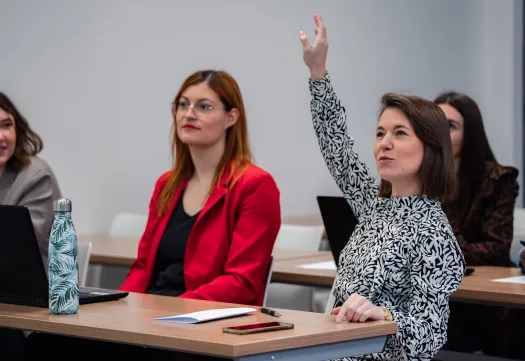 étudiante levant la main à un cours